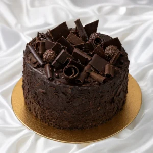 Chocolate overload cake covered in dark
  chocolate ganache, shards, curls and chunks