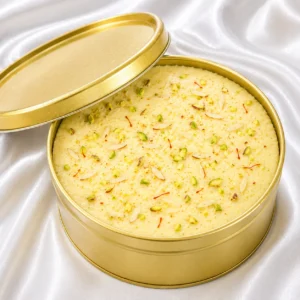 Rasmalai cake with saffron-tinted cream,
  rasmalai pieces, pistachio and almond garnish