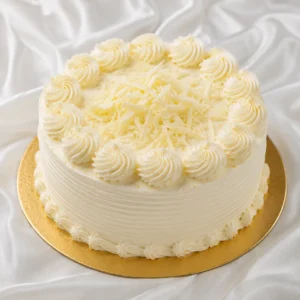 Round vanilla cream cake with smooth
ivory frosting and delicate swirls on a gold cake board